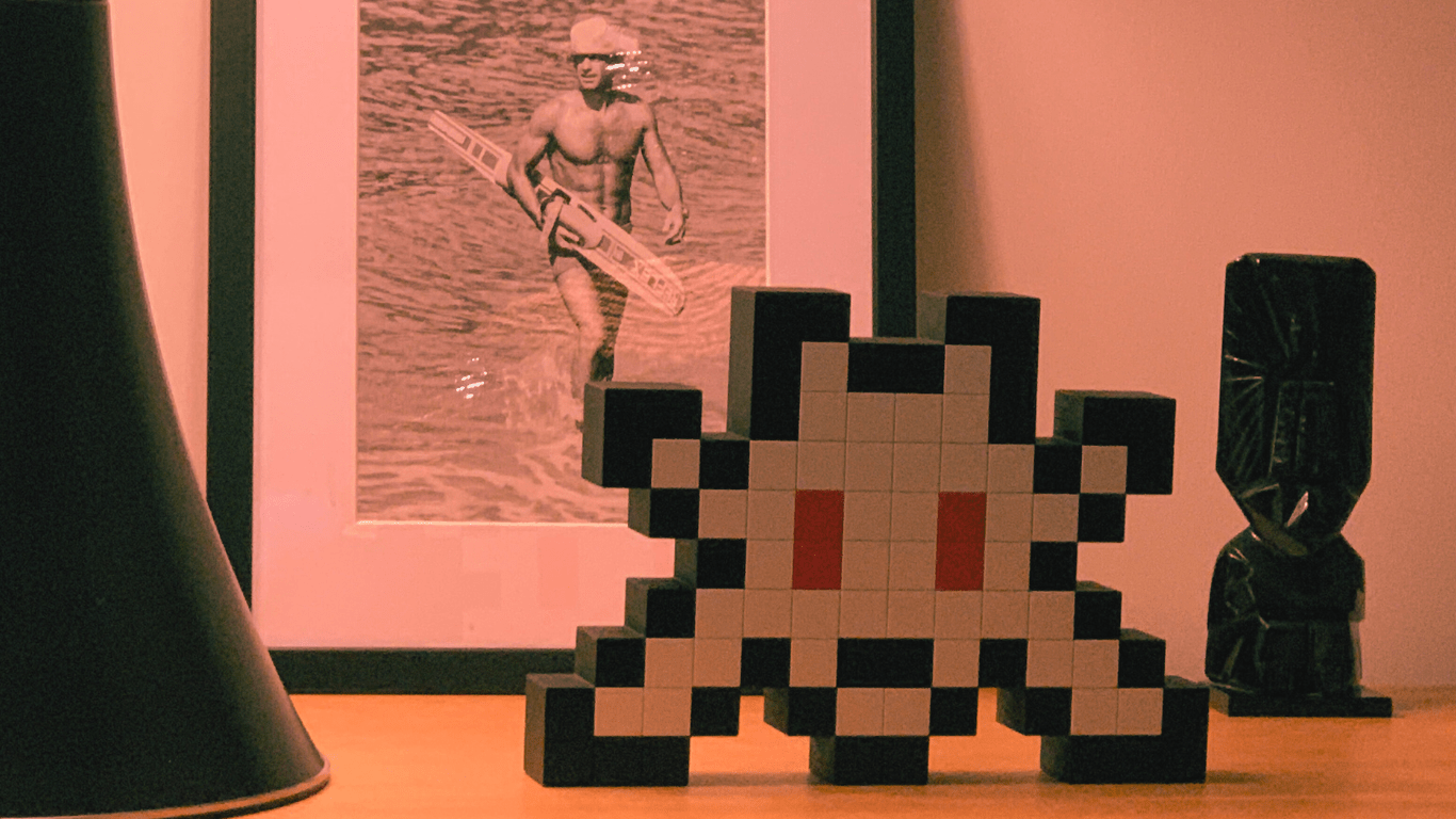 Jean-Paul Belmondo et sculpture Invader en résine - Rencontre visuelle entre l'icône du cinéma français et l'esthétique pixelisée du street art d'Invader.