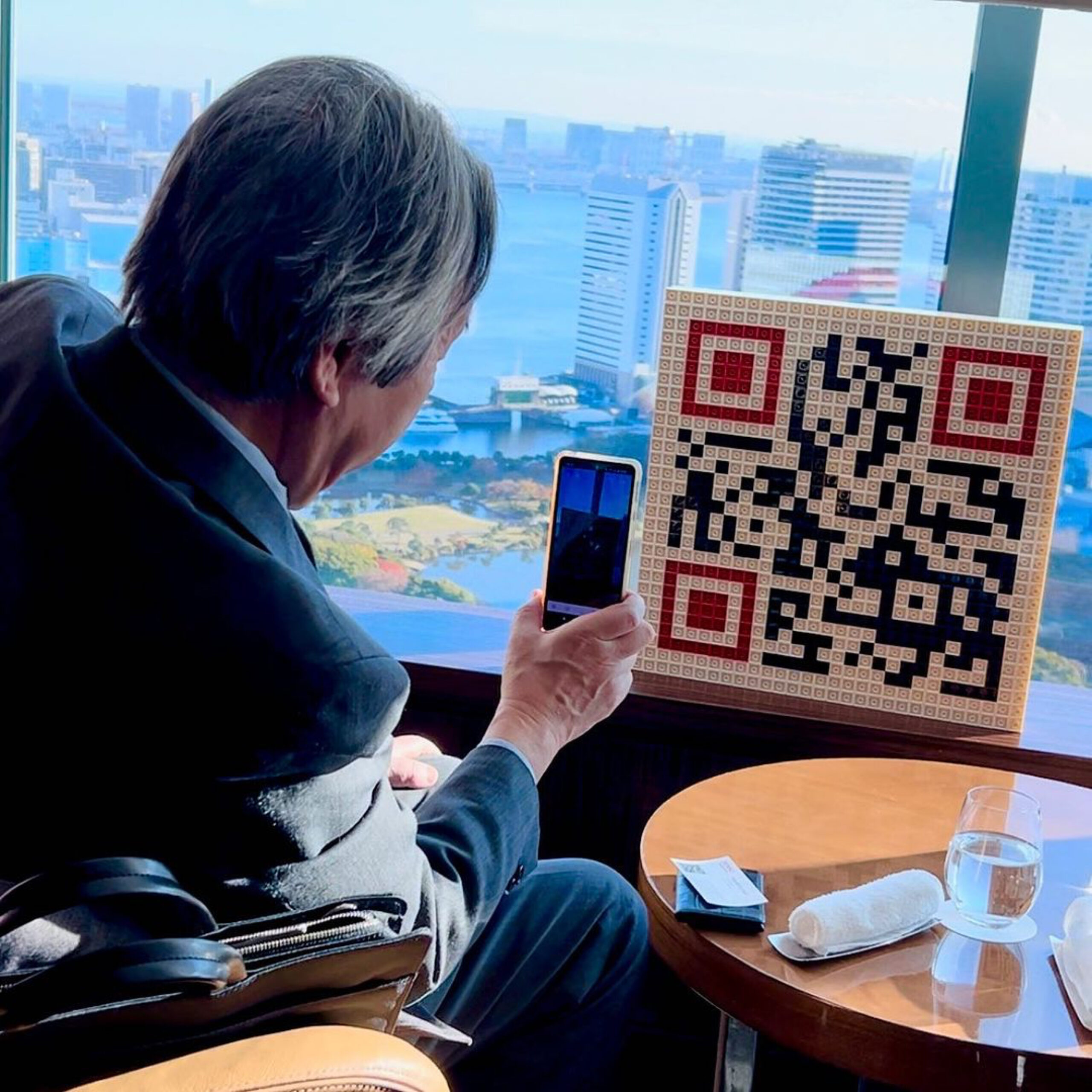 Masahiro Hara, l'inventeur du QR Code, scannant une œuvre d'art créée par Qargo à Tokyo."