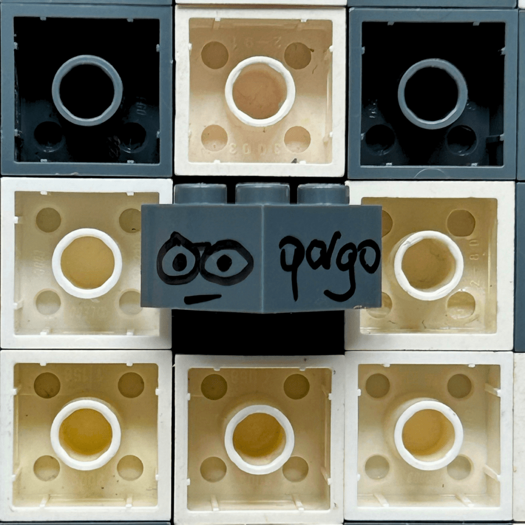 Modèle LEGO 3003 blanc signé par l'artiste qargo avec le smiley, utilisé comme Easter egg dans ses œuvres d'art.