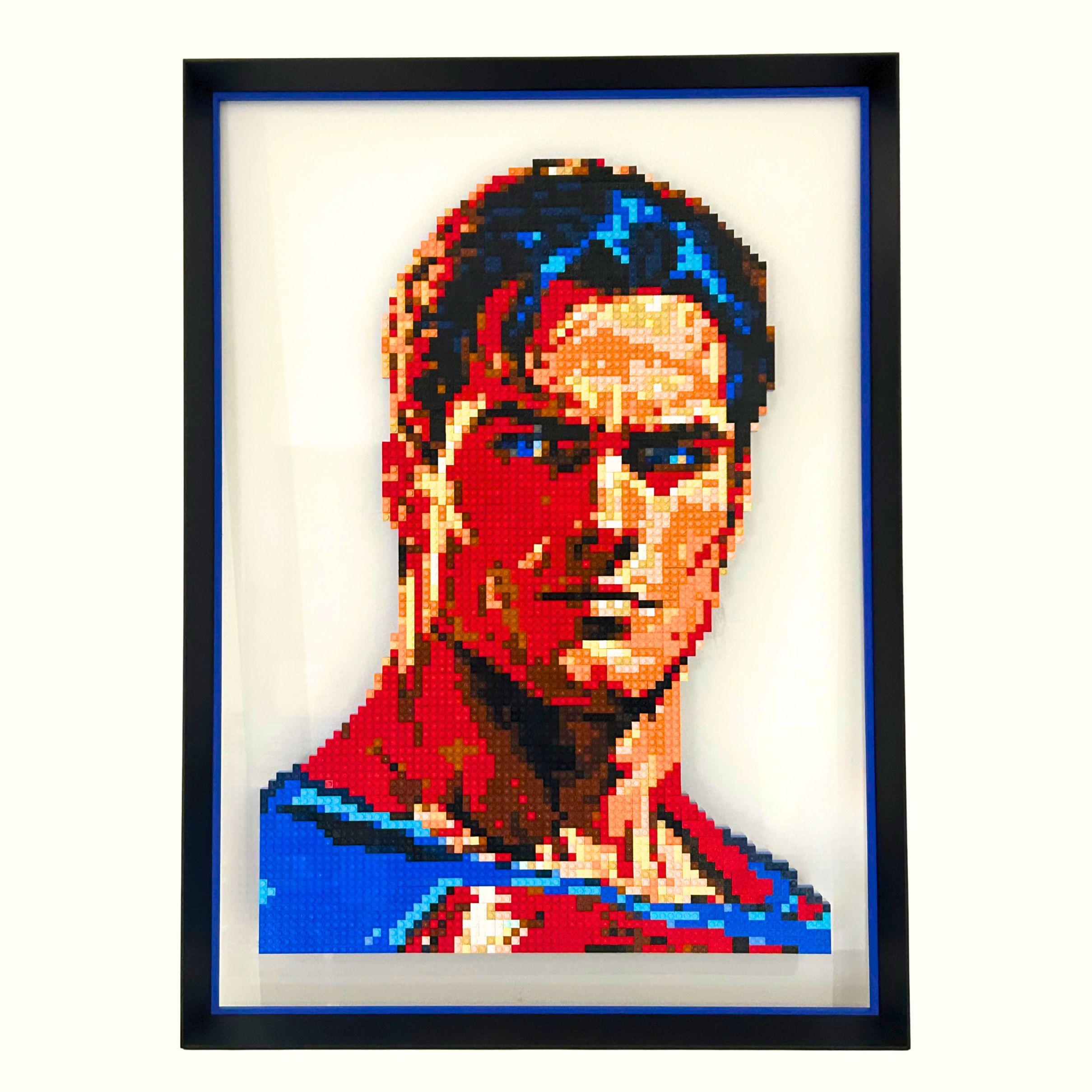 qargo-superman-marvel Portrait de Superman réalisé en briques LEGO®, monté sur plexiglas et encadré dans un cadre Nielsen en aluminium noir mat avec réhausse bleue, œuvre de l’artiste qargo.
