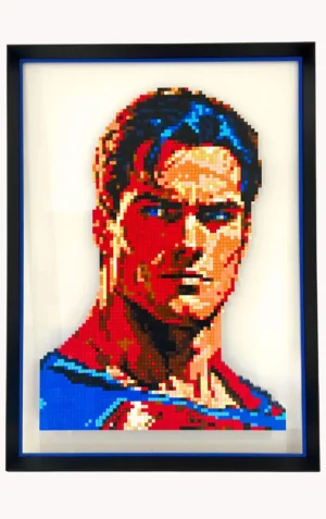 Portrait de Superman réalisé en briques LEGO®, monté sur plexiglas et encadré dans un cadre Nielsen en aluminium noir mat avec réhausse bleue, œuvre de l’artiste qargo.